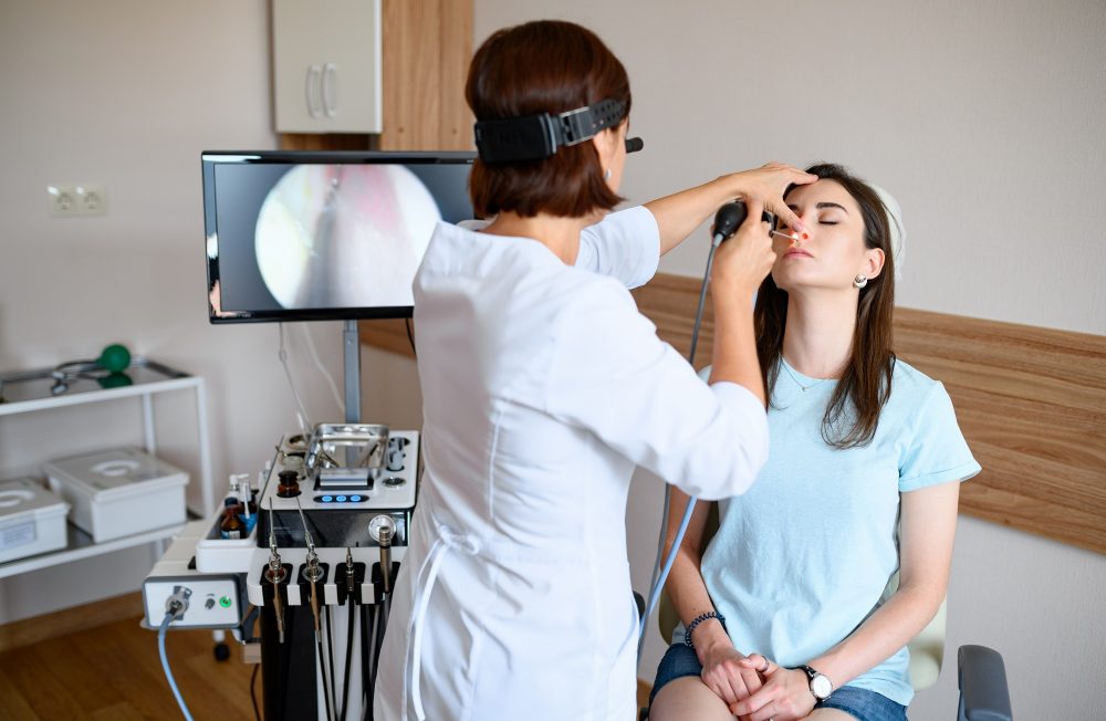 Female otolaryngologist and patient in office, exa