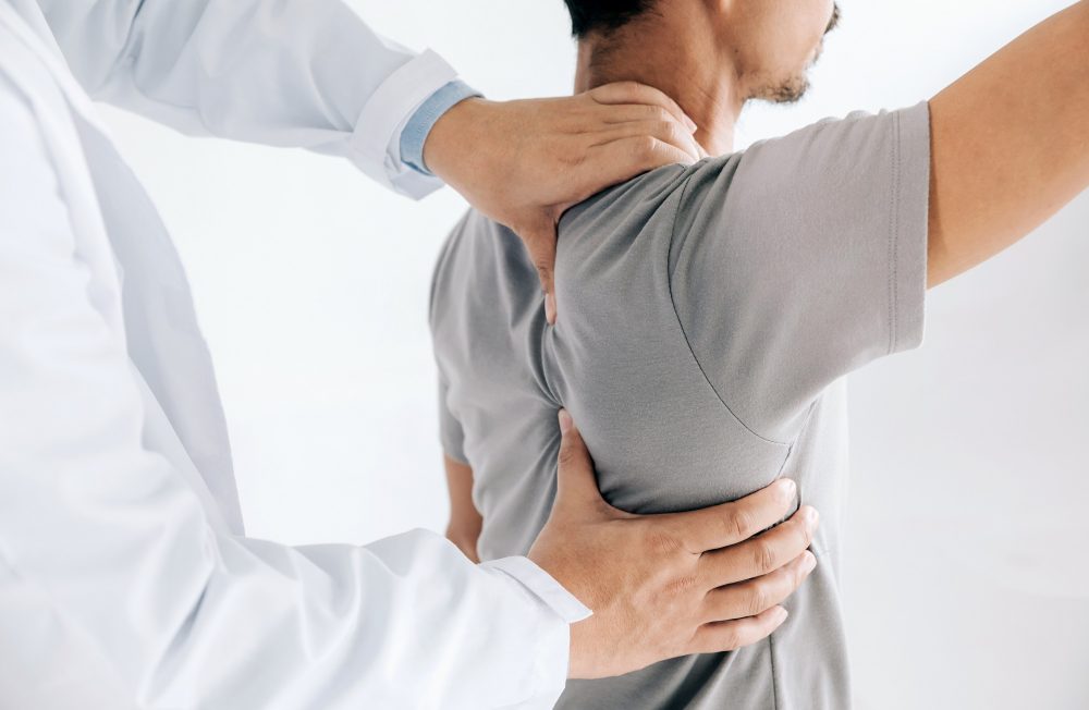 Physiotherapist doing healing treatment on man's back.Back pain